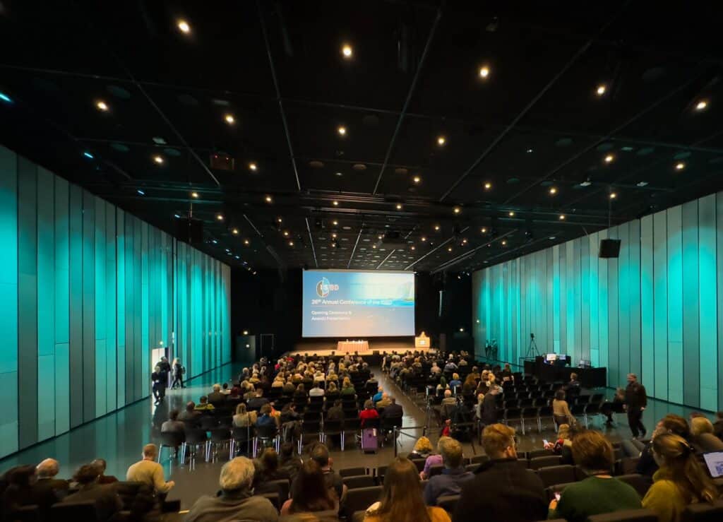 A conference hall with a high ceiling and teal-lit walls